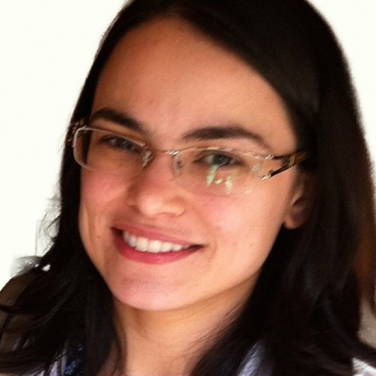 Retrato da Profa. Ariane Flávia Almeida Lage sorrindo, usando óculos de grau e blusa de tom azul-claro.